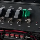 Toggle Switch Narva SPST 20A With Green Missile Switch Cover installed on dashboard panel