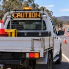 CODE 3 CD0012A amber LED message board showing CAUTION mounted on the rear of a traffic-management ute at a roadside work zone