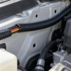 Black split convoluted tubing protecting a wiring loom in an engine bay
